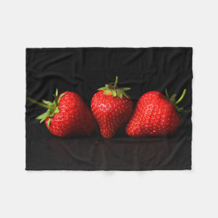 Drei Erdbeeren auf schwarzer Seite Fleecedecke