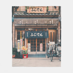 DREI FAHRRÄDER, DIE VOR GEBÄUDE PARKIERT WURDEN FLEECEDECKE