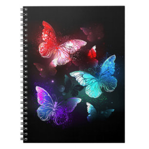 Drei glühende Schmetterlinge im Hintergrund Notizblock