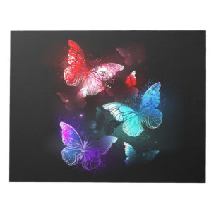 Drei glühende Schmetterlinge im Hintergrund Notizblock