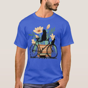 Drei schwarze Katzen, ein Fahrrad und ein Pot mit T-Shirt