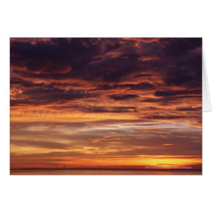 Dunkle Wolken in Orange gestreiftem Himmel