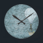 Dusk Blue Heißluftballon Steampunk Handschrift Runde Wanduhr<br><div class="desc">Entspricht anderen Steampunk-Heißluftballon-Designelementen wie Karten und Verpackungspapier. Ideal für Flugreisende und andere Fans. Dieses Design verfügt über einen Viktorianischen Steampunk Hot Air Ballon sanft fliegen vor einem Scrapbook Hintergrundbild gefüllt mit Handschrift gewaschen mit Schattierungen von weich, dunkelblau. Dieses ruhige Design wird von Männern und Frauen gleichermaßen geliebt und macht es...</div>