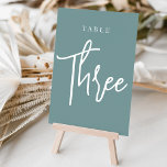 Dusty Aquamarin Hand Scripted Table DREI Tischnummer<br><div class="desc">Einfache und schicke Tischnummer-Karten in staubigen aquamarinen Aqua und Weiß machen eine elegante Aussage bei Ihrer Hochzeit oder Veranstaltung. Das Design bietet "table [number]" in einem spannenden Mix aus klassischen Serifen und handgeschriebenen Skripten. Design wiederholt sich auf beiden Seiten. Einzelne nummerierte Karten werden separat verkauft; bestellen Sie jede Tischnummer einzeln...</div>