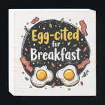 Egg zitiert for Breakfast Funny Feinschmecker Pun  Holzkisten Schild<br><div class="desc">Beginnen Sie Ihren Morgen mit einem Lächeln in diesem spielerischen "Egg-cited for Breakfast"-Design, das sich perfekt für Gourmets und Brunch-Fans eignet. In diesem hübsch von Hand gezeichnet Kunstwerk werden neben knusprigen Speckstreifen zwei sonnige Side-Up-Eier präsentiert, die alle Set vor einem skurrilen Hintergrund verstreuter Würzungen und lebendiger Typografie bilden. Die warmen...</div>