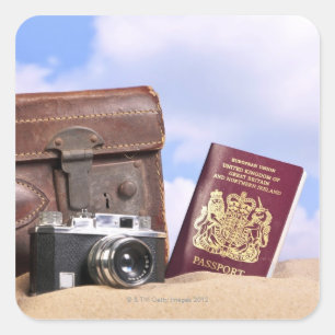 Ein alter lederner Koffer, eine Retro Kamera und Quadratischer Aufkleber