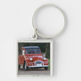 Ein alter roter Citroen 2CV Wagen mit einer lächel Schlüsselanhänger