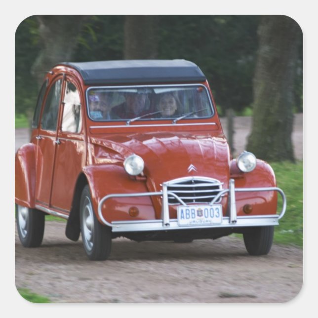 Ein altes, rotes Citroen 2CV Auto mit einer lächel Quadratischer Aufkleber (Vorderseite)