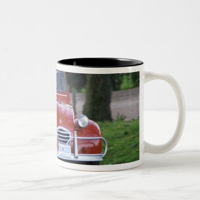 Ein altes, rotes Citroen 2CV Auto mit einer lächel Zweifarbige Tasse (Rechts)