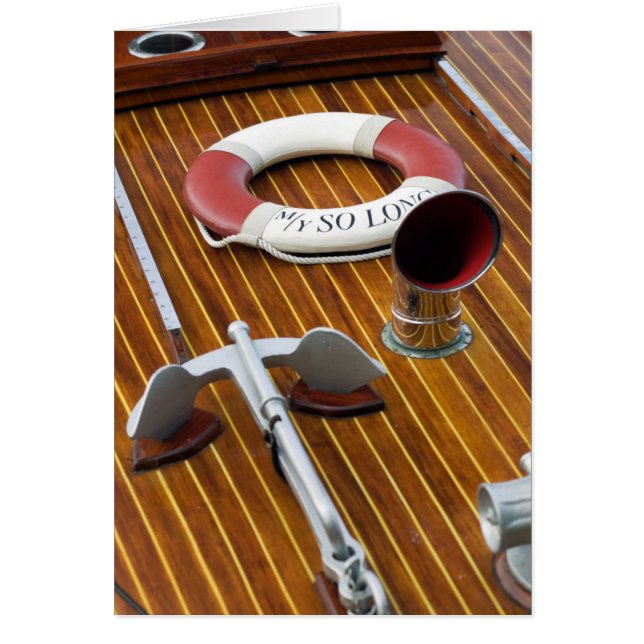 Ein Anker und eine Leben-Boje auf einem hölzernen (Vorne)