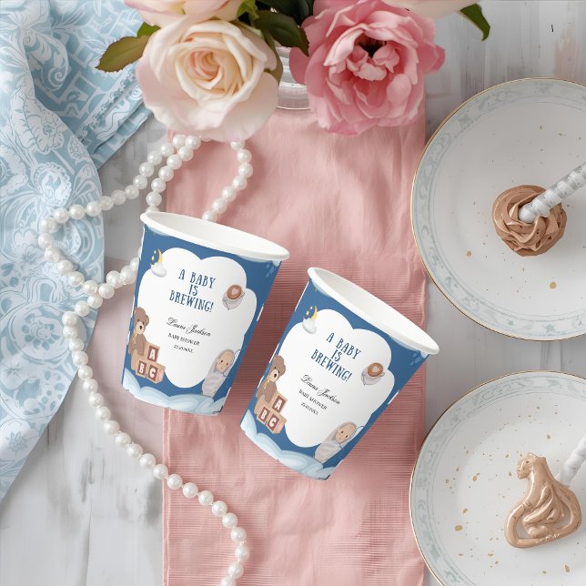 Ein Baby brütet eine Kaffeemaschine. Pappbecher (Von Creator hochgeladen)