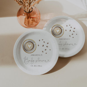 Ein Baby brütet eine Kaffeemaschine. Pappteller