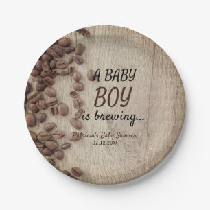 Ein Babyboy hält eine rustikale Kaffeemaschine au Pappteller
