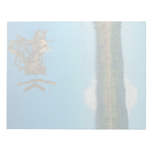 Ein Bergrestaub über einer Hecke Notizblock