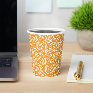Ein brauner und orangefarbener Teppich mit einem s Pappbecher
