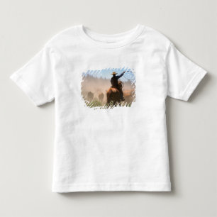 Ein Cowboy bei der Arbeit an der Herde auf einer R Kleinkind T-shirt