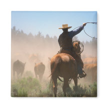 Ein Cowboy, der bei der Herde auf einer Rinder