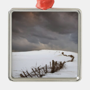 Ein defekter Zaun entlang einer Schnee Silbernes Ornament