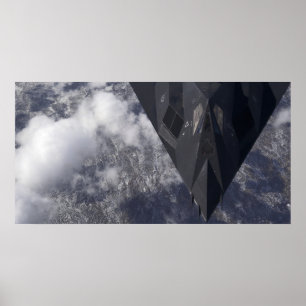 Ein F-117A Nighthawk fliegt hoch über das mountai Poster
