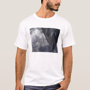 Ein F-117A Nighthawk fliegt hoch über das mountai T-Shirt