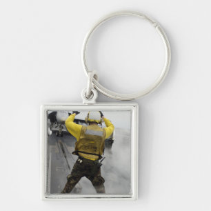 Ein Flugzeugdirektor signalisiert einer F/A-18C Schlüsselanhänger