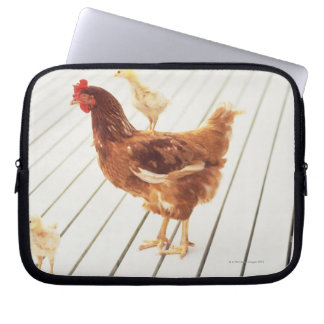 Ein Hühnchen und zwei Hühner auf einem Holzfußbode Laptopschutzhülle