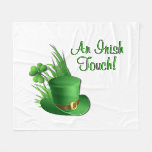 Ein irischer Leprechaun-Hut mit Kleeblatt im Gras Fleecedecke