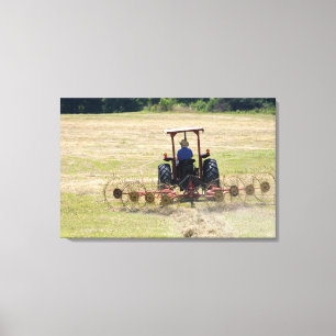 Ein junger Junge fährt einen Traktor zur Ernte Leinwanddruck