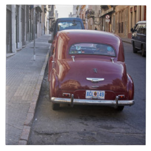 Ein klassischer alter roter Peugeot, der auf einer Fliese