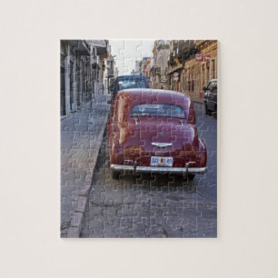 Ein klassischer alter roter Peugeot, der auf einer Puzzle