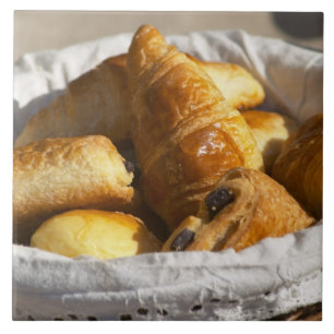 Ein Korbfrühstück mit Croissants und Fliese