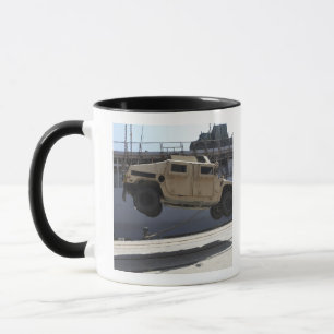 Ein Kran hebt ein M998 Humvee an Tasse