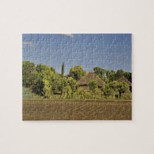 Ein landwirtschaftlich genutztes Feld vor Häusern  Puzzle