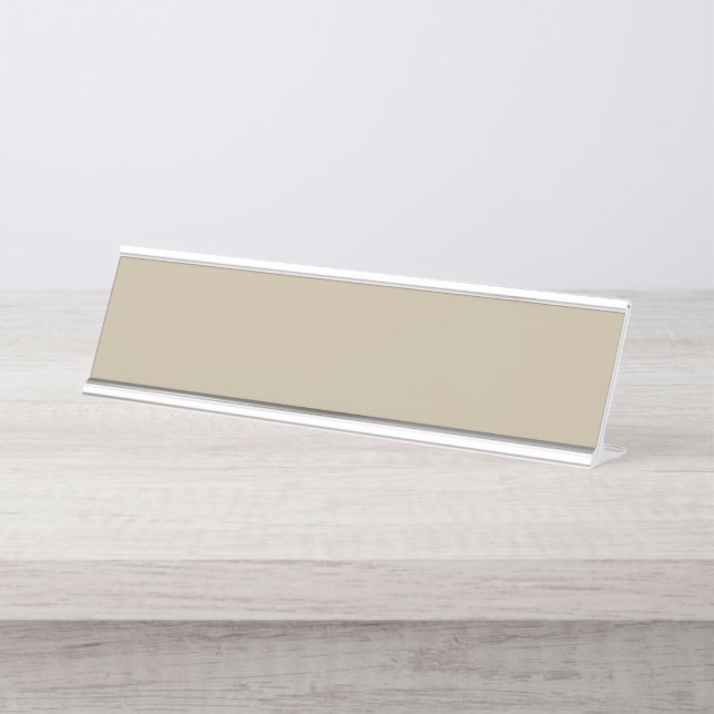 ein Mann in einem Anzug und Krawatte stehend vor e Schreibtischnamensplakette (Vorderseite )