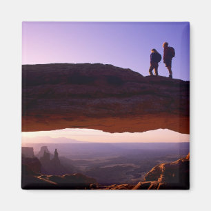 Ein paar beobachten Sonnenaufgang vom Mesa Arch in Magnet