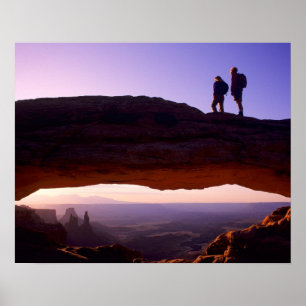 Ein paar beobachten Sonnenaufgang vom Mesa Arch in Poster