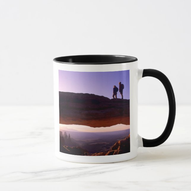 Ein paar beobachten Sonnenaufgang vom Mesa Arch in Tasse (Rechts)