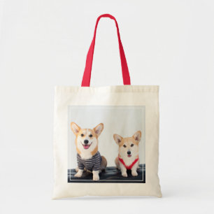 Ein Paar Corgis, die auf einer Bank sitzen Tragetasche