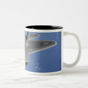 Ein Raubvogel F-22 bewegt sich in Position, um F2 Zweifarbige Tasse