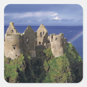 Ein Regenbogen trifft das mittelalterliche Dunluce Quadratischer Aufkleber