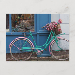 Ein rosa Fahrrad mit Korbkorb und Blume Postkarte