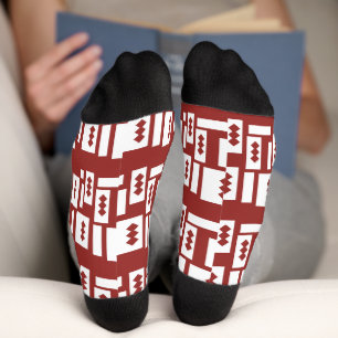 Ein roter Teppich mit einem textilen Muster wird a Socken