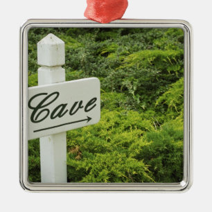 Ein Schild, das zum Weinkeller (Cave) zeigt in Ornament Aus Metall