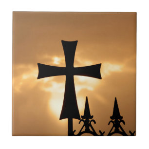 Ein schmiedeeisernes Kreuz auf einem Zaun Fliese