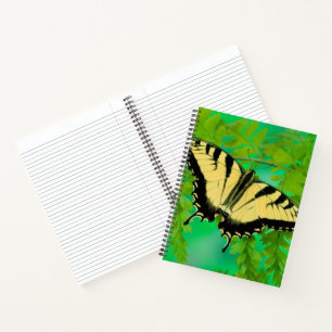 Ein Schwalbenschwanz Schmetterling landet Notizbuch