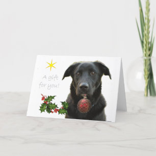Ein Schwarzer Labrador, der ein Geschenk bringt Feiertagskarte