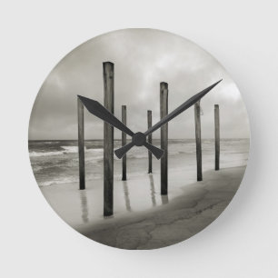 Ein Sepia tonte Schuss der alten Strandposten Runde Wanduhr