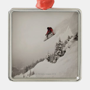 Ein Snowboarder springt weg von einer Klippe in Silbernes Ornament