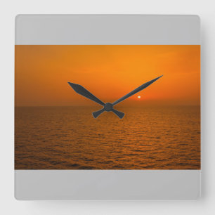 Ein Sonnenuntergang über dem Meer auf Wanduhr
