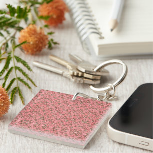 Ein Teppich mit roten und rosa Motiven ist mit ein Schlüsselanhänger